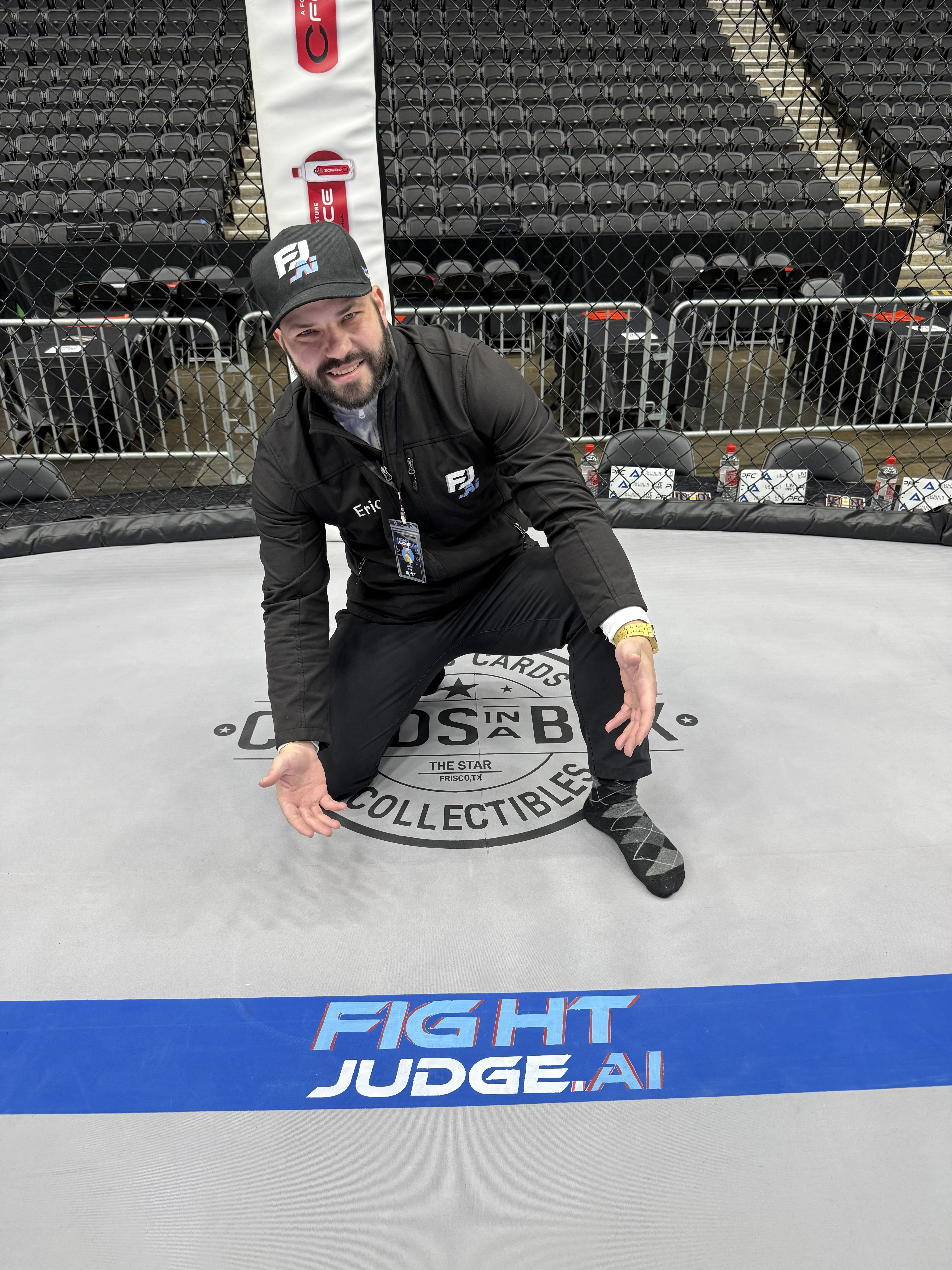 Fight Judge AI founder inside a live event cage wearing Fight Judge AI gear.
